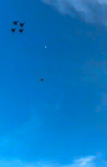 Jet fighter ballet in azure sky, celebrating Aviator's Day, precision soaring above, hint of moonlit tranquility, aerial artistry