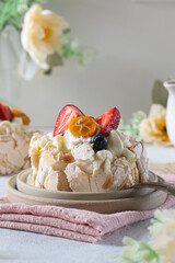 Delicious meringue dessert topped with fresh fruits and cream served on a rustic plate at a cozy cafe during a sunny afternoon