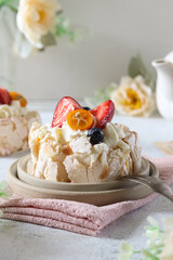 Delicious pavlova dessert topped with fresh fruits served on a ceramic plate during a casual afternoon gathering