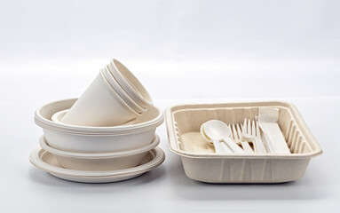 Biodegradable plates, cups, and cutlery set displayed on white background, showcasing eco friendly disposable tableware. Ideal for sustainable dining and reducing environmental impact