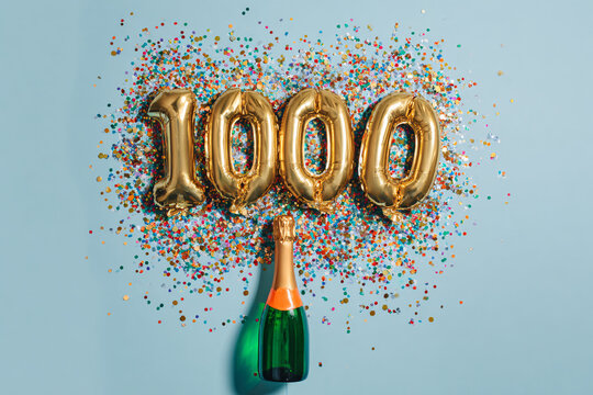 Celebrating a 1000 milestone achievement with a bottle of sparkling wine and vibrant confetti