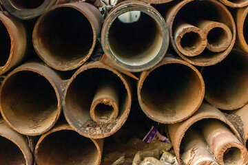 Stacked Rusty Metal Pipes in Construction Material Storage Yard