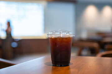 Close-up of Americano ice coffee or black coffee in cup mug on  wood desk office desk in coffee shop at the cafe in garden,during business work concept
