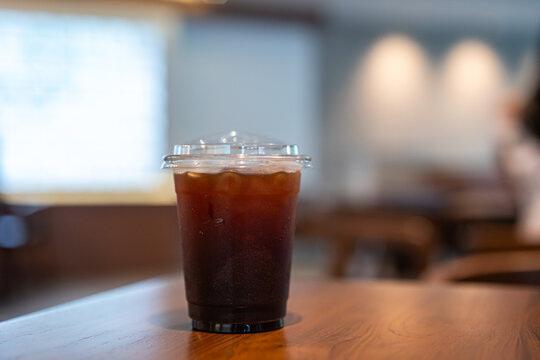 Close-up of Americano ice coffee or black coffee in cup mug on  wood desk office desk in coffee shop at the cafe in garden,during business work concept