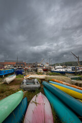 Colorful boats under a stormy sky. View of the quay on the River Deben in the historic town of Woodbridge in Suffolk, UK.