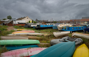 Colorful boats under a stormy sky. View of the quay on the River Deben in the historic town of Woodbridge in Suffolk, UK.