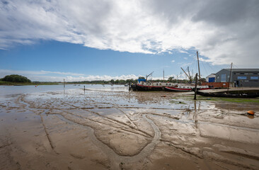 View of the quay showing mud at low tide on the River Deben in the historic town of Woodbridge in Suffolk, UK.