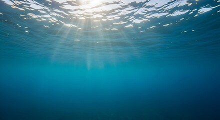Underwater view of sun rays penetrating clear blue ocean water surface image photo