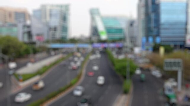 Bokeh view of road traffic and the office buildings of Dlf Cyberhub Cybercity Gurgaon Gurugram, New Delhi, India. Blurred background footage.