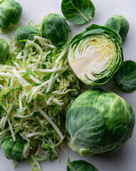 Shredded brussels sprouts with whole heads on a clean white background
