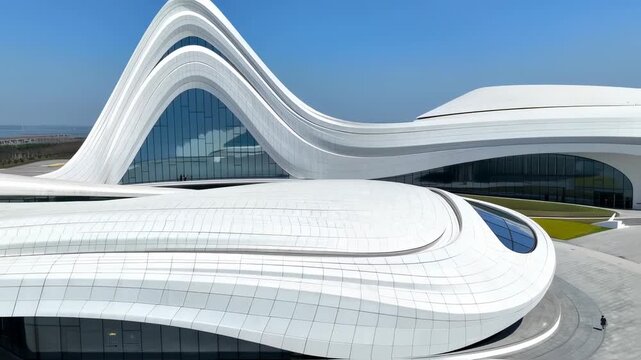 Modern architecture with futuristic building, white design, and blue sky.
