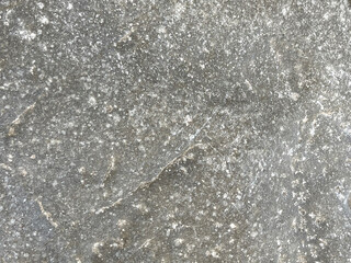 A textured gray surface with a speckled appearance, showcasing natural variations and patterns.