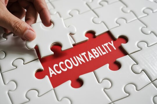 Hand Placing a Puzzle Piece, business accountability and teamwork, problem solving.