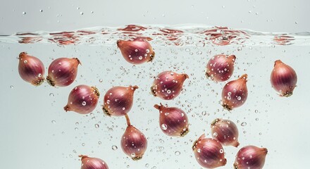 Multiple red shallots floating underwater with air bubbles and dynamic water splash, fresh organic produce photography for food and nutrition advertising