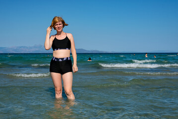 Woman standing in shallow sea water in summer