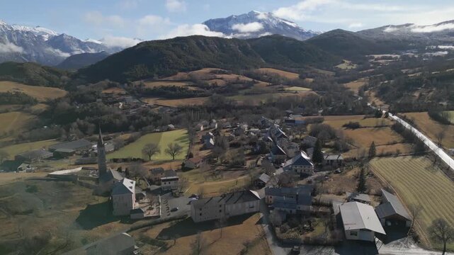 Dron en contrapicado muestra todo el peque&ntilde;o pueblo de Ubaye-Serre-Pon&ccedil;on en los Alpes franceses con su entorno natural.