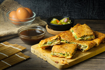 Martabak telur. Egg martabak or thick folded crepe made from egg, meat, and vegetables.