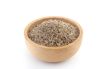 Fresh cumin seeds in wooden bowl isolated on white