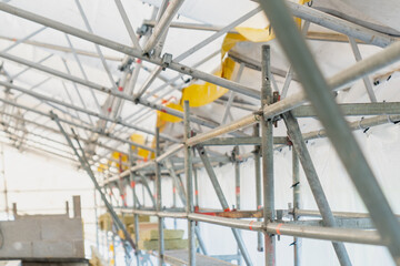 Construction scaffolding metal pipes structure with safety elements renovation building site framework industrial support system engineering architecture repair workshop project