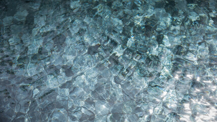 Clear water ripples reflect sunlight above a calm pool surface during midday, creating an inviting atmosphere for relaxation and enjoyment