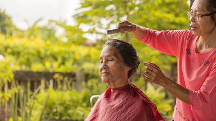 Community activity enhances connection with elderly during outdoor hair grooming session in a garden setting