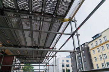 Construction scaffolding metal framework with safety platform renovation urban building site architecture repair infrastructure structural support Tallinn city development detail closeup