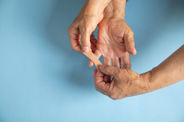 Daughter putting adhesive bandage on elderly mother hand.
