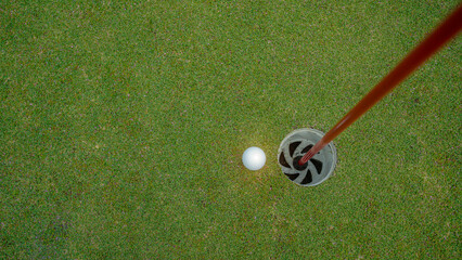 Golf ball is on a green lawn in a beautiful golf course with morning sunshine.