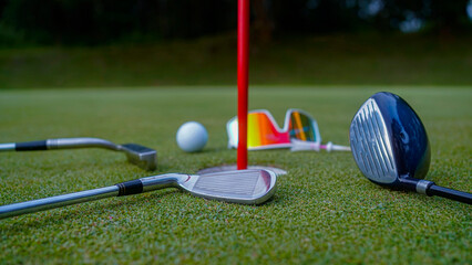 Close up of golf equipment on green grass.