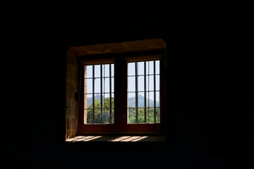 A window with a view towards the foot-hills of the Pyrenees Mountains in the town of Espelette, France.