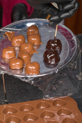 Heart-shaped sweets covered with liquid icing black chocolate