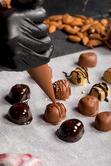 A confectioner decorates sweets with the help of a confectioner's bag