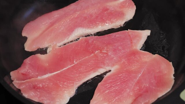 Cooking turkey breast on pan close-up. Preparing healthy dinner at home.