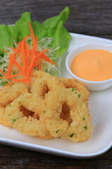 Breaded calamari with tartar sauce decorated on a black plate, Calamari with Herbal Tartar Sauce