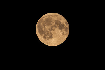 The bright Sturgeon Moon full moon shines in the dark night sky on August 9, 2025, showing detailed craters and lunar surface texture.