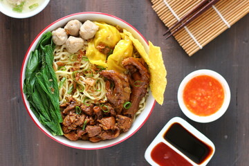 Mie ayam baso. noodle with chopped chicken and meat balls. served with cracker and boiled vegetables.