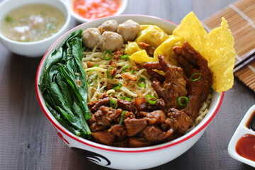 Mie ayam baso. noodle with chopped chicken and meat balls. served with cracker and boiled vegetables.