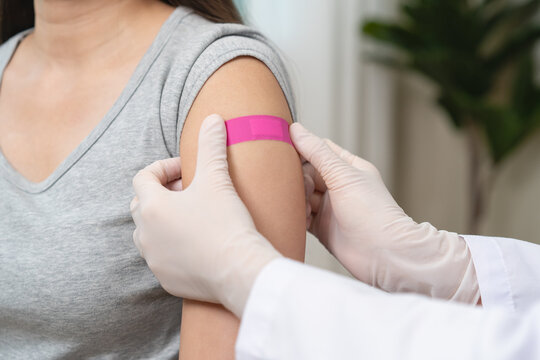 People getting a vaccination to prevent pandemic concept. Woman in medical face mask  receiving a dose of immunization coronavirus vaccine from a nurse at the medical center hospital