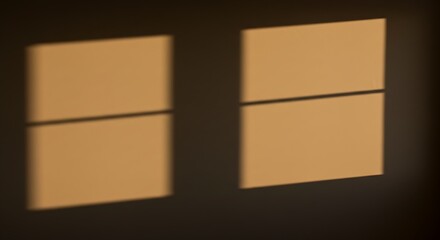Obraz premium Warm golden sunlight casts soft windowpane shadows on a textured wall, creating a serene and inviting atmosphere.