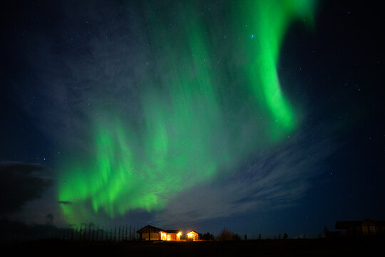 Beautiful northern lights in the dark sky under the house for travellers in Iceland. Aurora in Iceland 