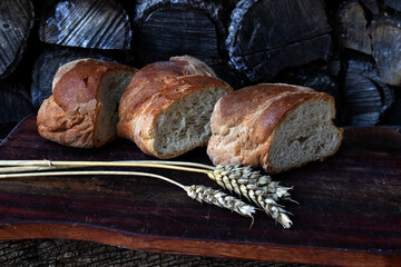 Rustic image of a wooden board with pieces of bread and ears of
