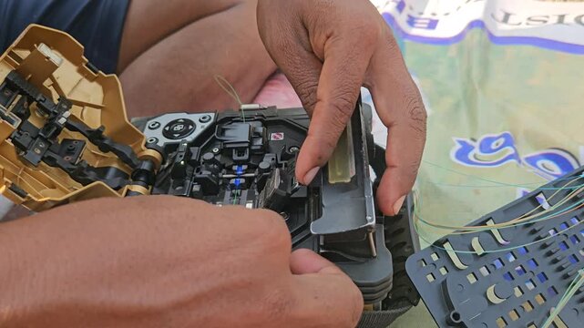 A fiber optic fusion splicer machine in action, captured in 4K 30fps in India, as a technician carefully joins optical cables to ensure a stable internet signal with precise, low-loss connections.