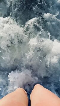 Slowmotion, nagie, kobiece stopy, spacer w morzu, morskie fale, widok z g&oacute;ry na stopy w ruchu, woda morska, pomalowane paznokcie.