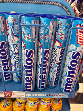 Thessaloniki, Greece - august 09, 2025: title: vertical tubes of mentos mints in blue packaging are neatly arranged and displayed in a metal rack for sale, with a special two-for-one price