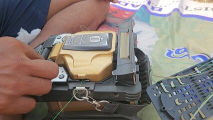 A fiber optic fusion splicer machine in action, captured in 4K 30fps in India, as a technician carefully joins optical cables to ensure a stable internet signal with precise, low-loss connections.