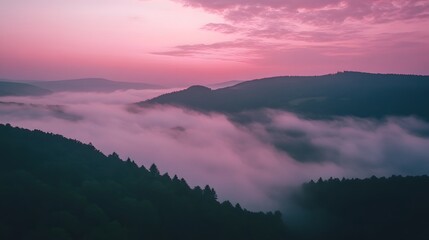 Obraz premium Aerial view of a mountain covered in fog under dramatic cloudscape