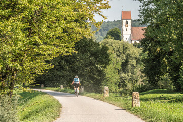 Fahrradweg am Neckardamm im Bruckenwasen in Plochingen mit Stadtkirche St. Blasius