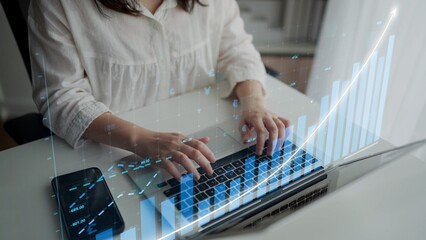 A business professional engages with a laptop, focused on digital financial data and growth metrics, enhancing productivity and strategic insights in a modern office setting. Copula
