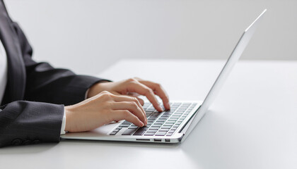 ビジネスシーン、ノートパソコンで作業するビジネスウーマンの手元