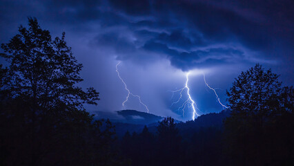 Dramatic Lightning Strikes Over Dark Mountain Forest Landscape